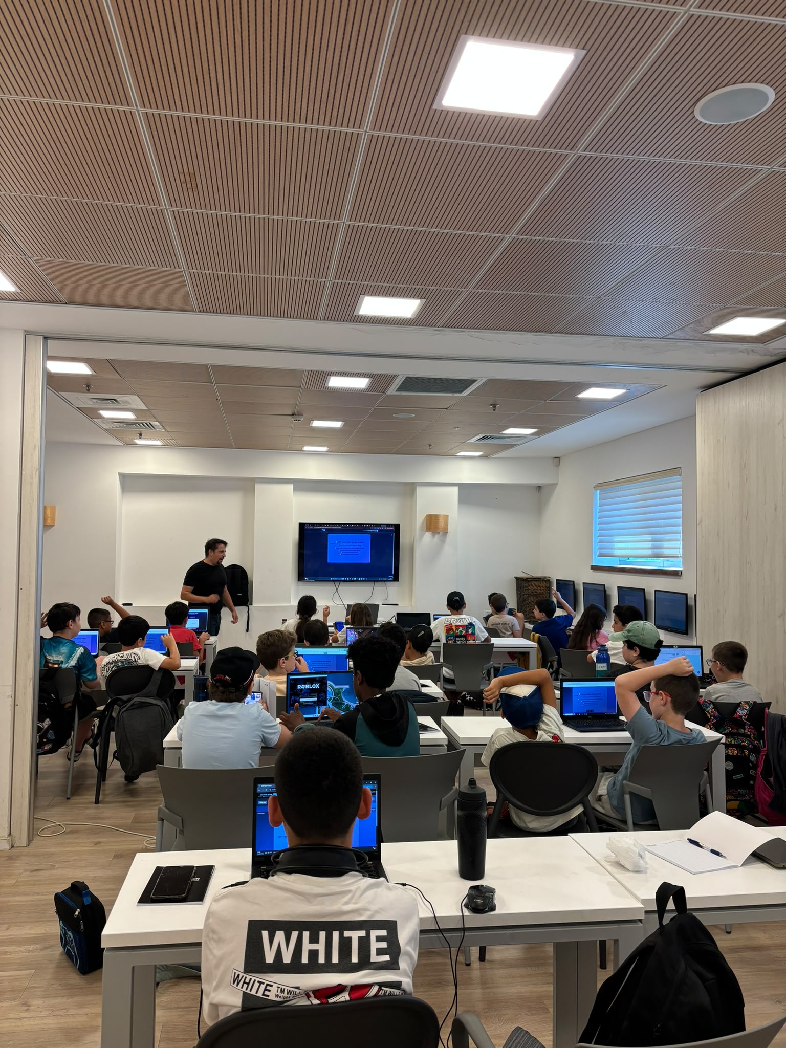 ילדים לומדים מול מחשבים בכיתה של Israel Cyber Campus